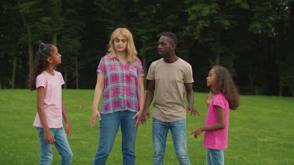 Joyful Multiethnic Family with Girls Stacking Hands