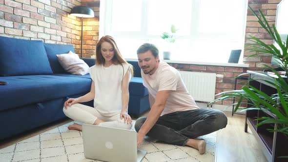 Beautiful Couple Practice Yoga at Home