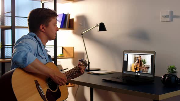 Man Learning To Play Guitar Online at Home