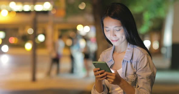 Woman using cellphone at night 