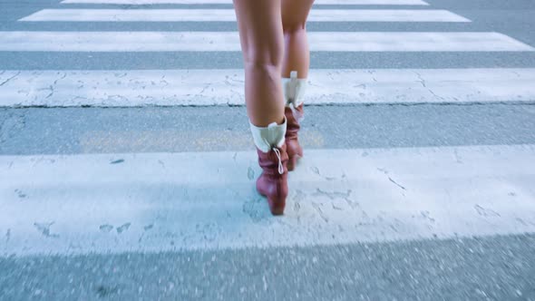 Woman in Boots Crosses Road at Wide Pedestrian Crossing