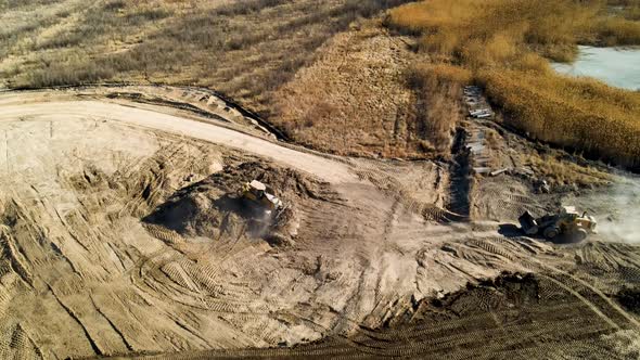 Bulldozers landscaping a large developmental construction site - aerial view