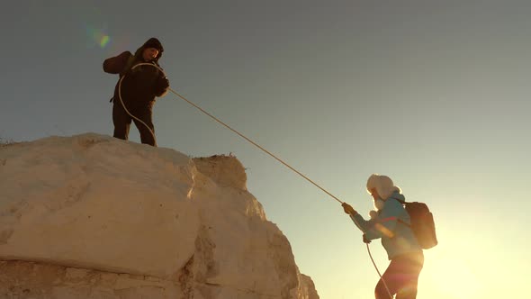 Climbers Climb Mountain on a Rope. Free Woman and Man Traveler Climbs a Mountain. Teamwork of