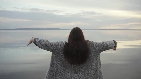 Young Woman Standing Back and Spreading Her Hands When Looking at the Sea