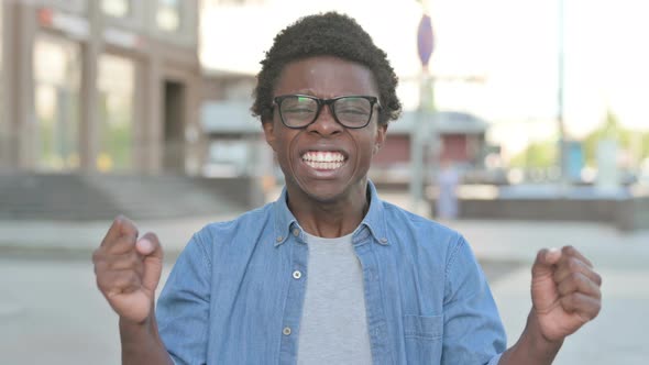 Excited Young African Man Celebrating Success Outdoor