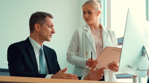 Two Business People Talk Project Strategy at Office