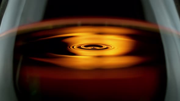 Super Slow Motion Detail Shot of Swirling Whiskey in Glass at 1000Fps alt