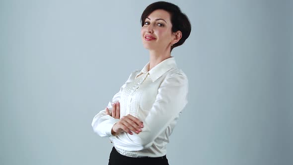 Young adult businesswoman smiling with friendly toothy smile with arms crossed on chest