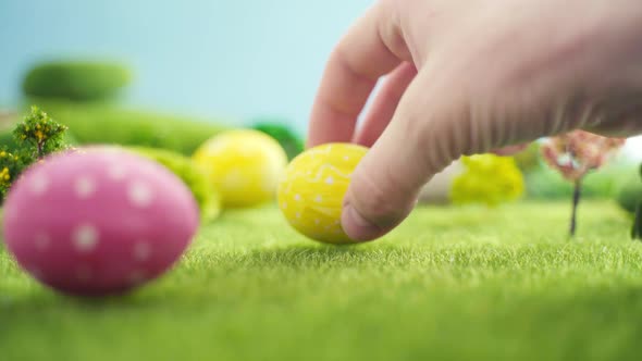 Hand Laying Easter Egg on Grass