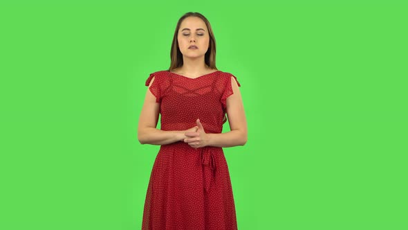 Tender Girl in Red Dress in Anticipation of Worries, Then Guilty Hides Her Eyes. Green Screen