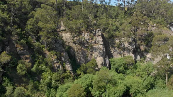 Forward moving aerial shot of a deep canyon leading to a waterfall in the bush of Australia.