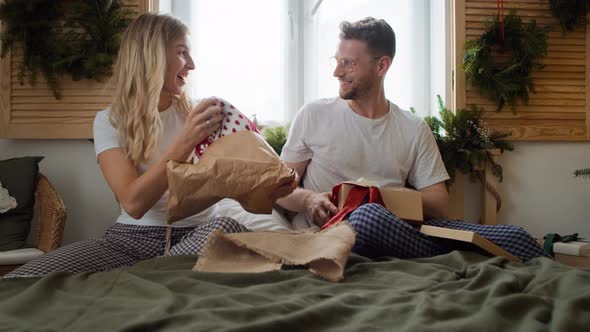 Happy couple opening Christmas gifts. Shot with RED helium camera in 8K