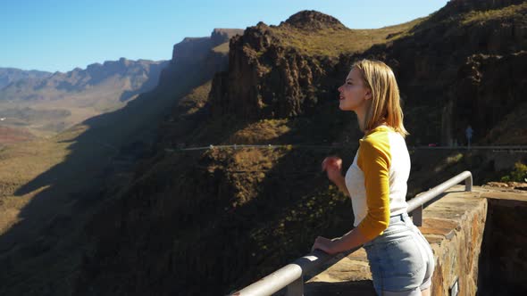 Female with a Golden Hair Leaning Over to See the Panoramic View of Gran Canaria