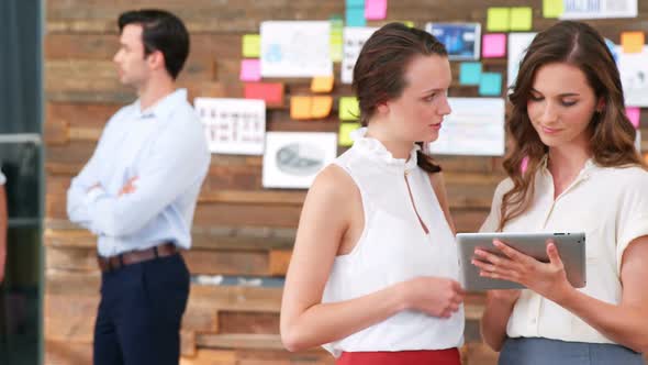 Business executives discussing over digital tablet