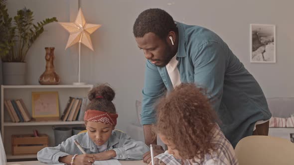 Father Helping Daughters with School Homework