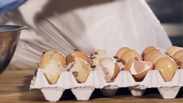 The Cook Cleverly Breaks Up a Group of Fresh Eggs for Baking  Closeup