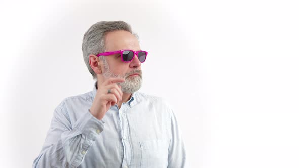 Middleaged Greyhaired Man Looks Away Taking Off Sunglasses When Looks on the Left White Background