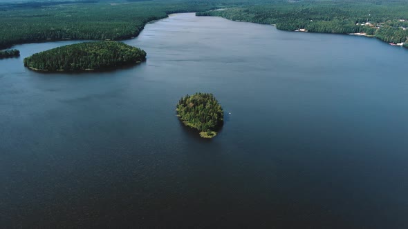 Wide Lake with Couple of Small Islands and Forest on Banks