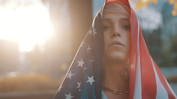 Portrait Shot of Young Blond Woman with USA Flag Over Her Head on Election Day