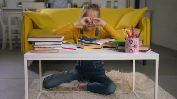 Tired Schoolgirl Rubbing Her Eyes While Studying