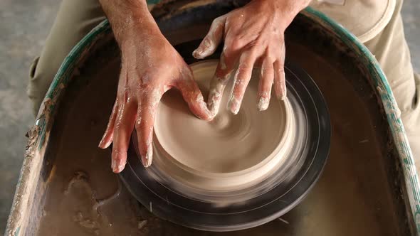 Mid section of potter making pot