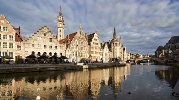 Golden hour timelapse of historic buildings in Ghent reflecting in the river canal. Belgium alt