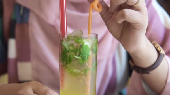 Muslim Women Drinking Glass of Orange Juice at Cafe