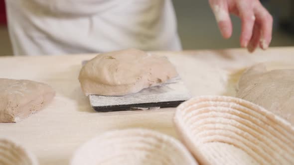 Portioning dough for making bread, baker weighs dough on digital scale, man weighing dough in bakery