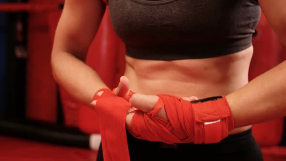 Female boxer wearing red strap on wrist in fitness studio