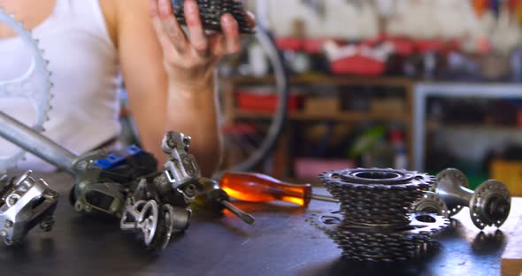 Woman repairing parts of bicycle at workshop 4k