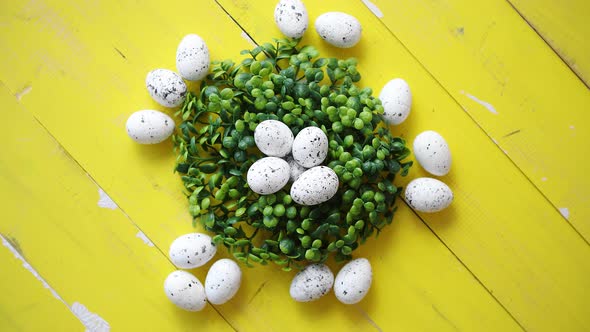 Green Decorative Easter Quail Eggs Wreath on Yellow Wooden Table