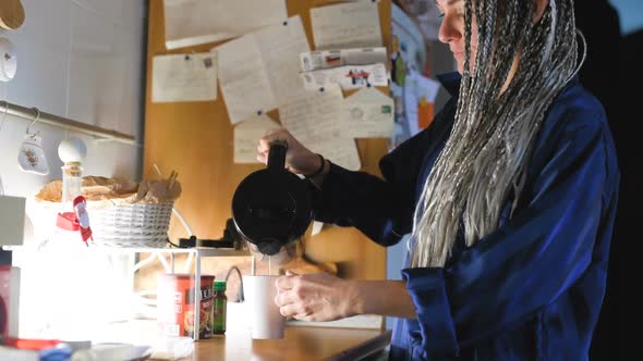 Mid adult woman indoor at home preparing a cup of hot tea