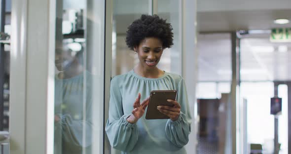 Video of happy african american businesswoman using tablet in office