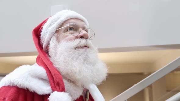 Santa Claus walking inside a house. Going up stairs.