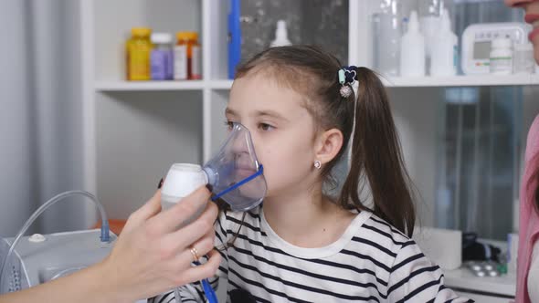 Portrait of a Woman Pediatrician and a Little Girl with an Inhalation Mask From a Nebulizer