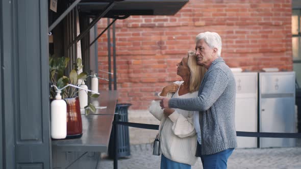 Side View of Mature Couple on Date Ordering Meal at Food Truck Outdoors