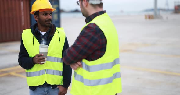 Multiracial engineer men controlling shipping containers inside industrial port