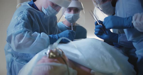 Doctors Performing Aesthetic Surgery While Patient Lying on Operating Table