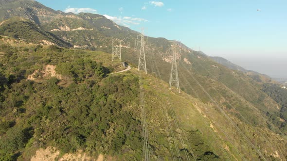 Aerial of Power Lines on a Verdant Mountain