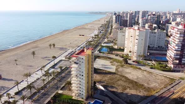 Aerial drone footage of new buildings with swimming pools near the beach of San Juan, Spain.