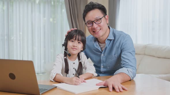 Homeschool Asian little young girl learning online class from school teacher using computer laptop.