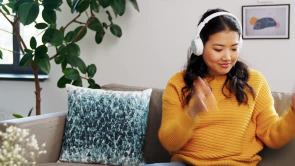 Happy Asian Woman in Headphones Listening To Music