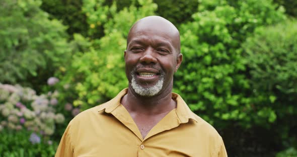 Animation of african american senior man smiling at camera in garden