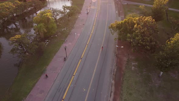 Person walking and working out by Palermo Park in Buenos Aires city at sunset. Top down view.