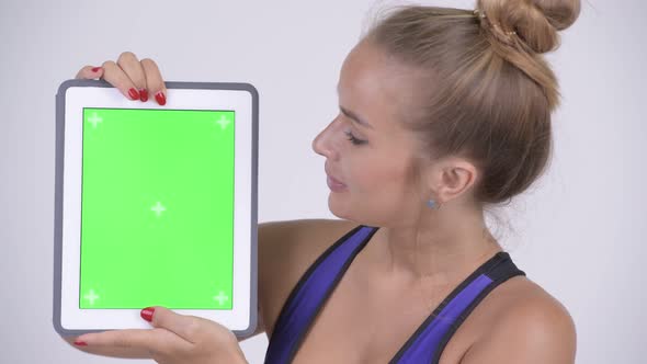 Face of Happy Young Beautiful Blonde Woman Showing Digital Tablet