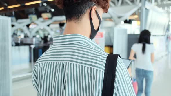 Asian male and female wearing protective face mask in airport termina