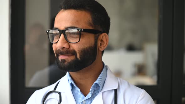 Intelligent Professional Male Indian Doctor Looking at the Camera and Smiles