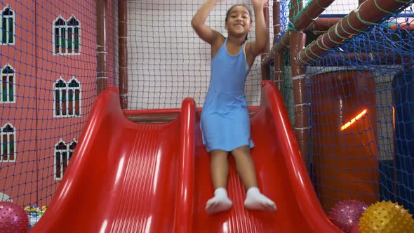 AfricanAmerican Girl in Dress Slides Into Pool with Balls