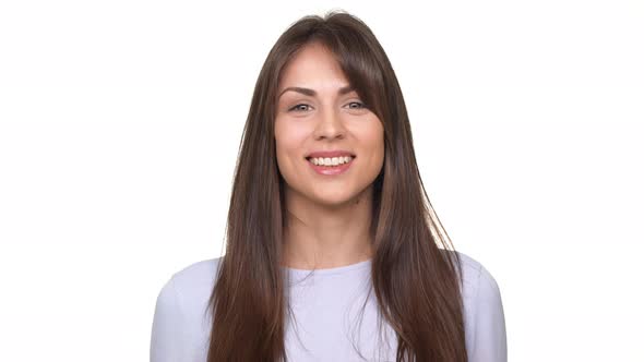 Attractive Young Brunette Caucasian Female Smiling and Laughing Over White Background