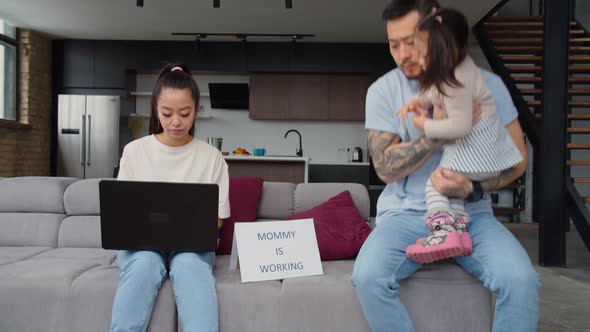 Busy Asian Businesswoman Ignoring Husband with Child